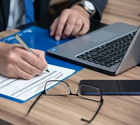 hombre escribiendo en un documento